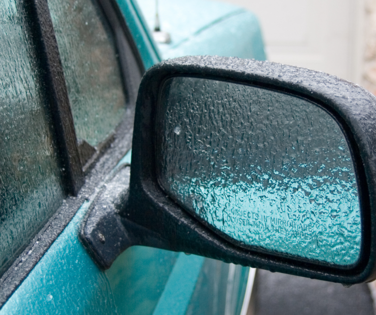 A rear view mirror iced over from freezing rain